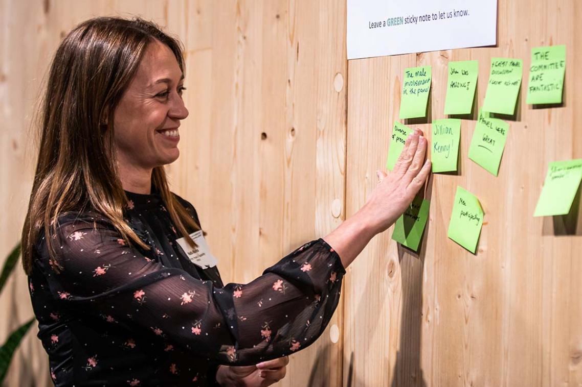 Woman sticking post-it notes on a board.
